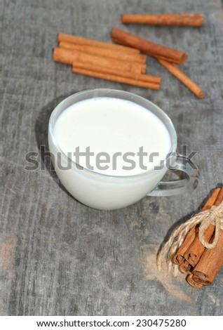 cup of hot milk with cinnamon, closeup , wooden background