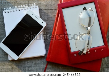white smartphone and e-book on wooden background.Notepad,diary,record