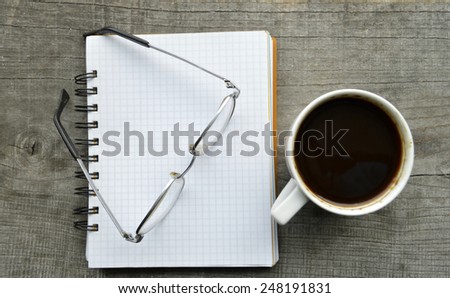 red e-book,Notepad,reading glasses,hot Cup of coffee on wooden background