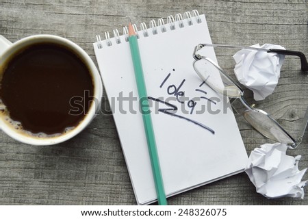 Notepad,reading glasses,hot Cup of coffee on wooden background