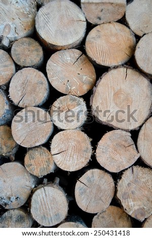 Background of dry chopped firewood logs stacked up in a pile