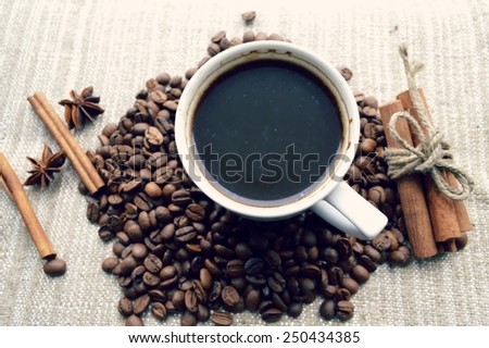 a hot Cup of coffee,coffee beans,Notepad,cinnamon,spices