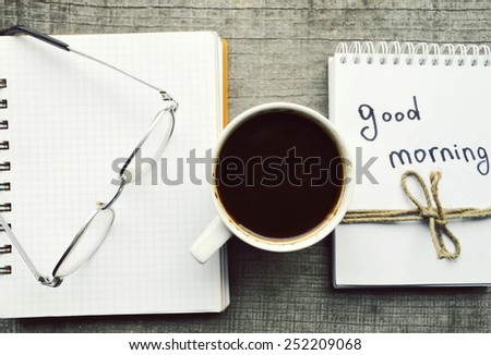 e-book.Notepad,reading glasses,hot Cup of coffee on wooden background.