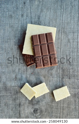 bar of chocolate, coffee beans, hazelnuts, walnuts, cinnamon, coriander, spices .chocolate bar, candy bars,  different chocolate sweets on a wooden background