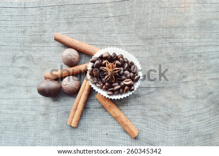 bar of chocolate, coffee beans, hazelnuts, walnuts, cinnamon, coriander, spices .chocolate bar, candy bars,  different chocolate sweets on a wooden background.big choice of various sweets