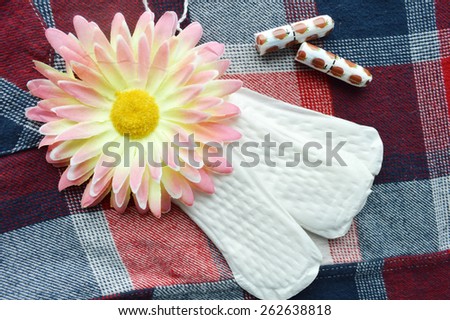 Woman hygiene protection, close-up.menstruation calendar with cotton tampons,orange Gerber,Sanitary pads on a red background