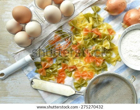 Metal pasta maker machine and ingredients for pasta,Raw homemade pasta ,Still life of preparing pasta on rustic wooden background