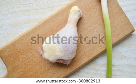 raw chicken thigh with herbs on a wooden Board