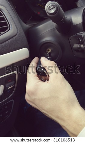 Hand holding car key for starting the car.Male hand with car key on car background