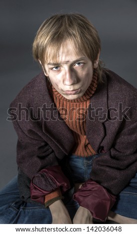 Young actor showing beggar. Old coat and dirty face.