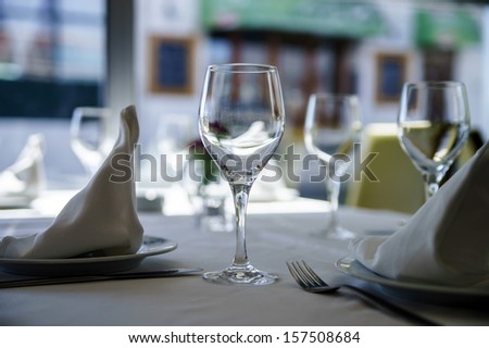 Fine restaurant dinner table setting by wineglass and napkin