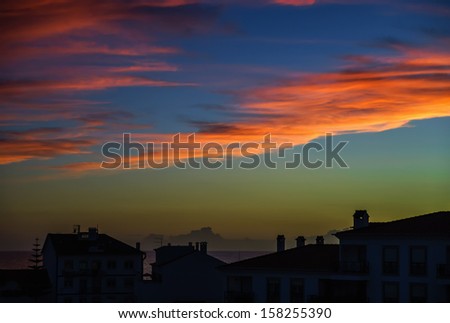Colorful sunset over houses silhouettes in small portugal village