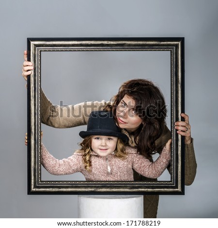 Mother and daughter posing with frame of picture