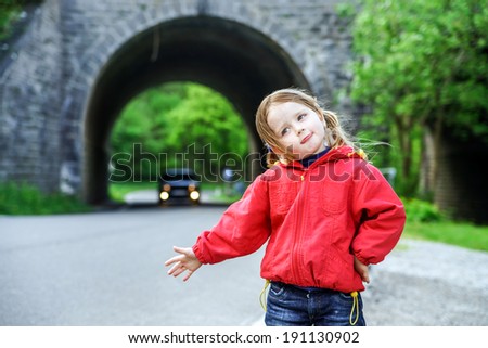 Hitch-hiking by little girl. Auto stop on the road.