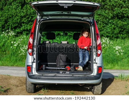 Little traveller staying in the car luggage. Family travel.