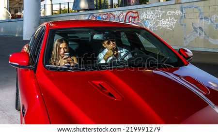 Couple of lovers posing with red luxury sport car