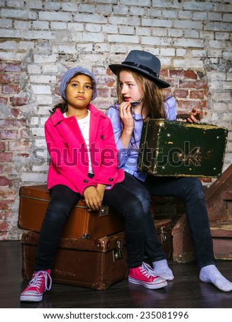 Two girls waiting for the train with vintage suitcases