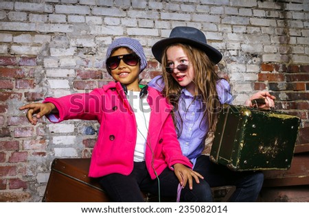 Two girls waiting for the train with vintage suitcases
