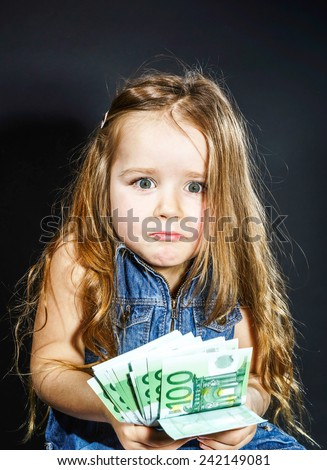 Cute little girl with money euro in her hand. Business concept. How much it costs to be happy.