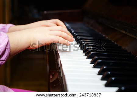 Little girl studying to play the piano at home
