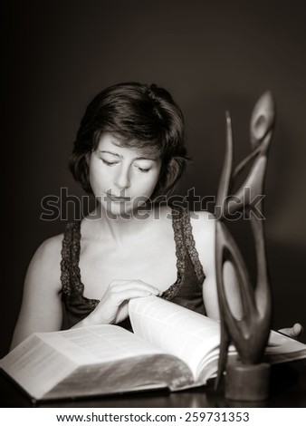 Young woman reading big book, concentration and attentiveness, isolated