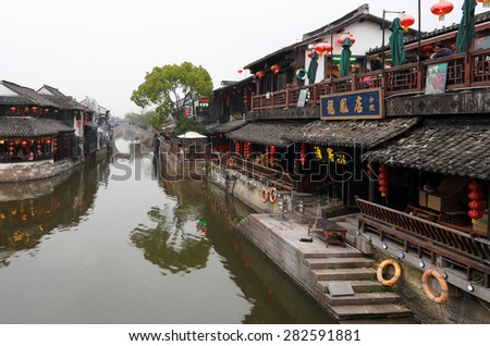 Xitang, China - April 15, 2015: Chinese Traditional Water Village Xitang, which is located in Zhejiang Province, China. Photo Shows traditional Chinese Houses Along the River on a Cloudy Day.