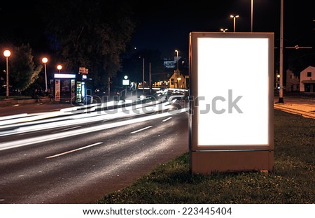 Billboard in the city street by night, blank screen