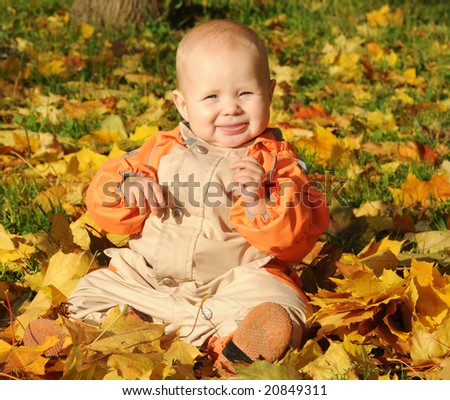 7-months Smiling Baby-girl sitting on maple leaves