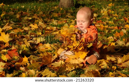 7-months Smiling Baby-girl with maple leaves on hands.