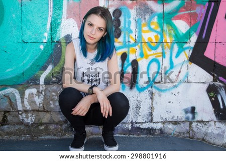 Young beautiful girl agains graffiti wall