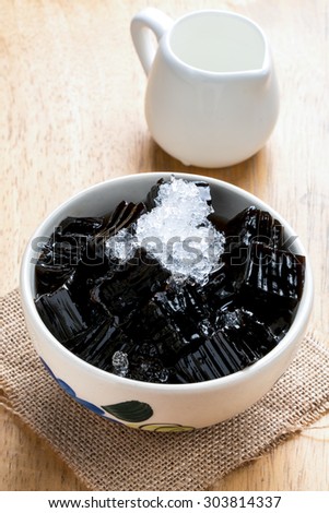 Grass jelly (choa kuay) with crushed ice in wood cup on wooden plate for Thirst time