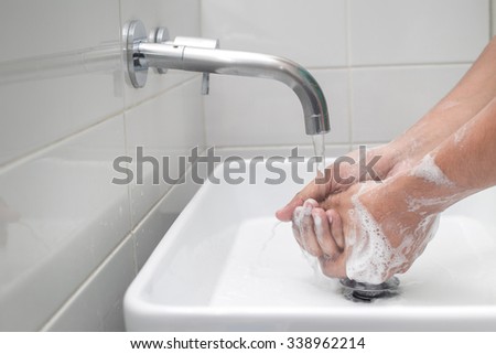 Close-up of hands under stream of water from faucet