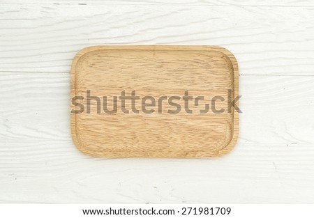 wooden plate on white wooden table, top view