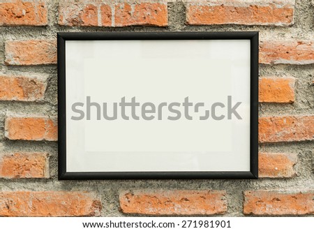 blank black picture frame on old brick wall