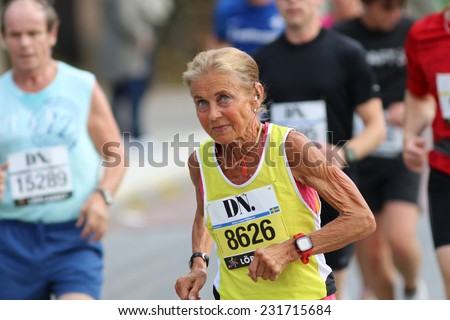STOCKHOLM - SEPTEMBER 13, 2014: Old woman in very good shape running in the Halvmarathon running event (21 km), Sept 13, 2014 in Stockholm, Sweden
