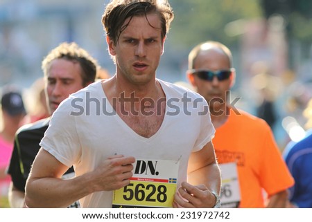 STOCKHOLM - SEPTEMBER 13, 2014: Running focused good looking young man in the Half marathon running event (21 km), Sept 13, 2014 in Stockholm, Sweden