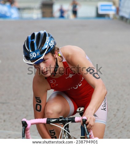 STOCKHOLM - AUG 23, 2014: Magdalena Mielnik (POL) cycling and fixing the a shoe after the transition in the Women\'s ITU World Triathlon series event August 23, 2014 in Stockholm, Sweden