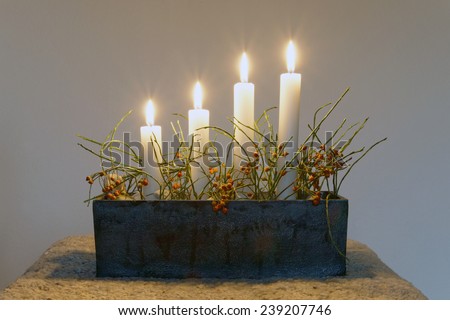 Typical swedish advent candle stick holder with decorations and all four candles burning the 4th sunday in december
