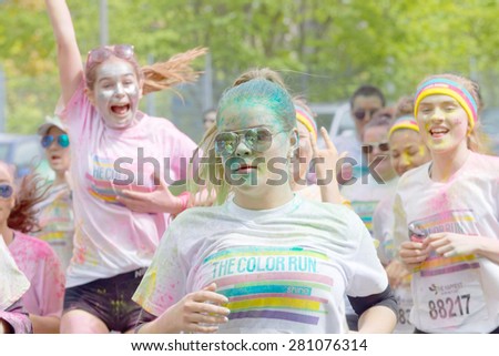 STOCKHOLM - MAY 23, 2015: Group of happy young girls covered with color powder running in the public event The Color Run, May 23, 2015 in Stockholm, Sweden