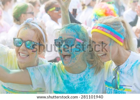 STOCKHOLM - MAY 23, 2015: Three happy girls covered with color powder wearing sun glasses taking a selfie in the public event The Color Run, May 23, 2015 in Stockholm, Sweden