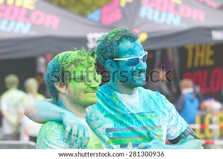 STOCKHOLM - MAY 23, 2015: Two happy men wearing sun glasses totally covered with color powder in the public event The Color Run, May 23, 2015 in Stockholm, Sweden
