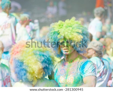STOCKHOLM - MAY 23, 2015: Two participants wearing large hippie style wigs and covered with blue and green color powder in the public event The Color Run, May 23, 2015 in Stockholm, Sweden