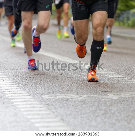 STOCKHOLM - MAY 30, 2015: Close up of orange running shoes and de-focused shoes and legs behind in the ASICS Stockholm Marathon event May 30, 2015 in Stockholm, Sweden