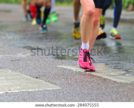 STOCKHOLM - MAY 30, 2015: Close up of pink running shoes and de-fucused shoes and legs behind in the ASICS Stockholm Marathon event May 30, 2015 in Stockholm, Sweden