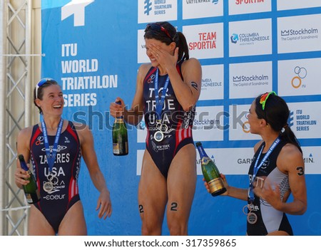 STOCKHOLM - AUG 22, 2015: Sarah True, Zaferes and Hewitt on the winner\'s stand squirting champagne in the Women\'s ITU World Triathlon series event August 22, 2015 in Stockholm, Sweden