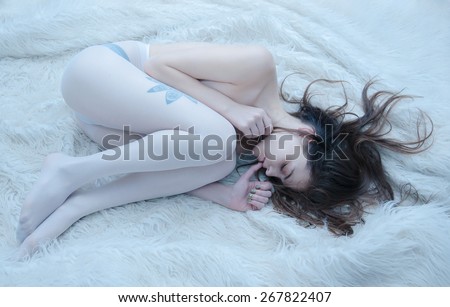 Portrait of a young girl sleeping in bed. Tattoo. Hipster. Skinny nude body.