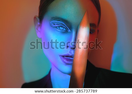 Beauty Girl Portrait with knife and Colorful Makeup, Hair, Nail polish. Colourful Studio Shot of Woman. Vivid Colors. Manicure and Hairstyle. Fashion Art. Beautiful Girl. Vogue Style. Art. Design.