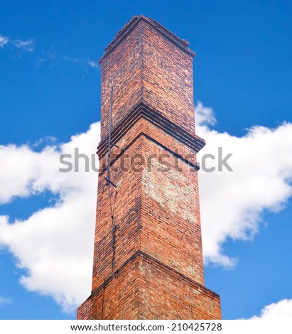 Close up brick chimney on the roof with cloudy blue sky background