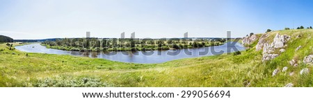 Panoramic view at the rocky shore with a village in the distance. Russian nature.
