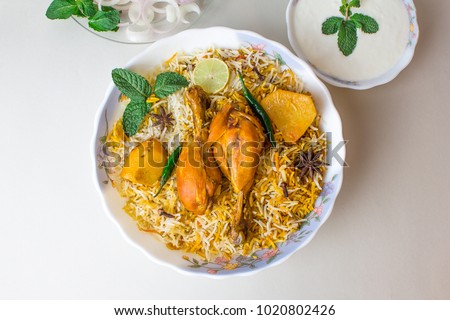 Delicious spicy chicken biryani in white bowl on white background, Indian or Pakistani food.